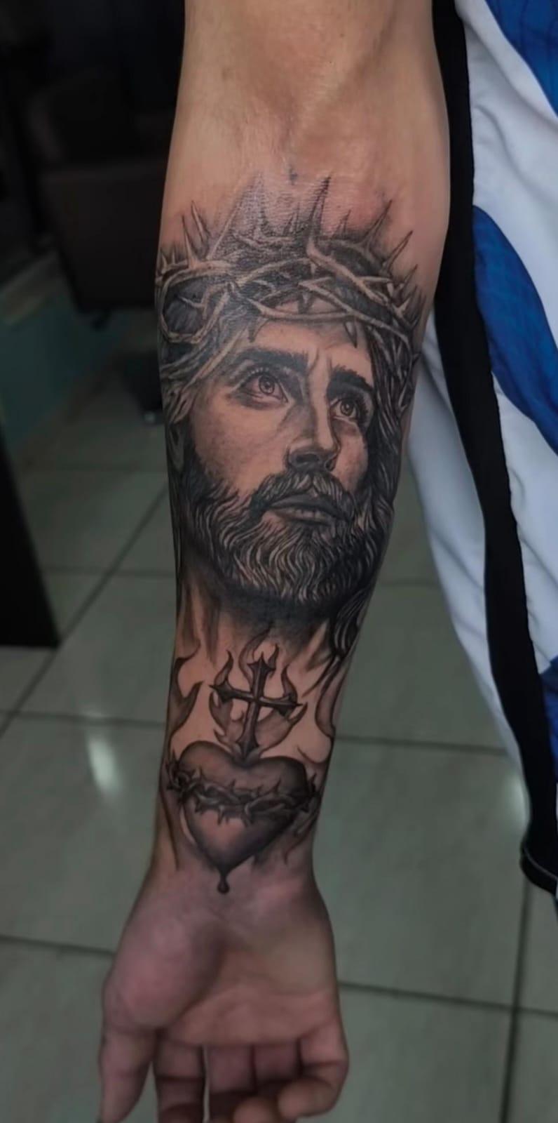 Tatuagem grande religiosa no antebraço